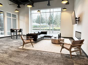 A living room with a couch and chairs and a television